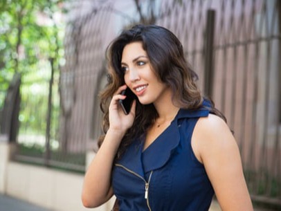A middle-aged Indian woman is talking on the phone